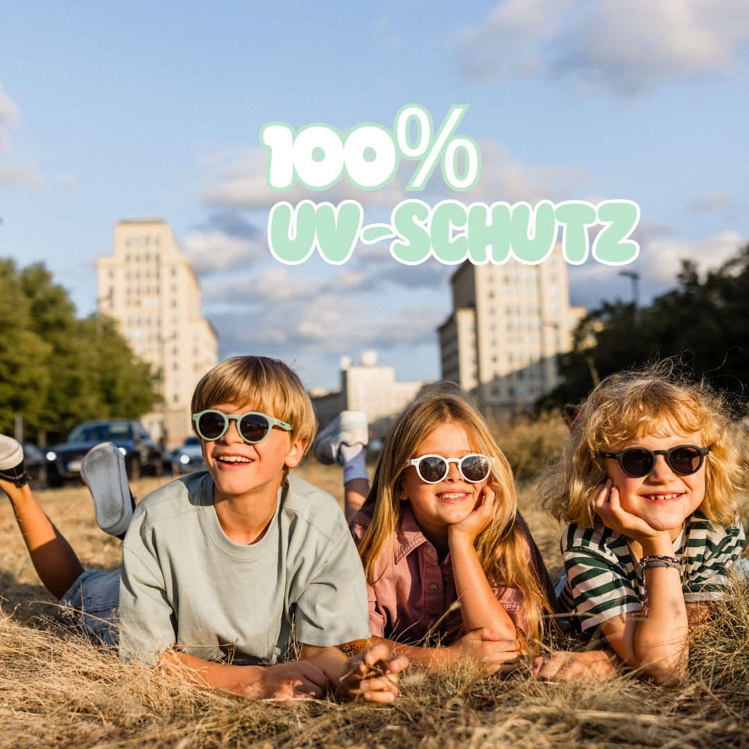 Kinder sitzen in der Sonnen mit Kindersonnenbrillen die 100% UV-Schutz bieten